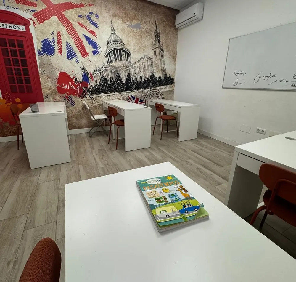 Aula de inglés del Centro Lorena Fernández, con mesas y mural de Londres